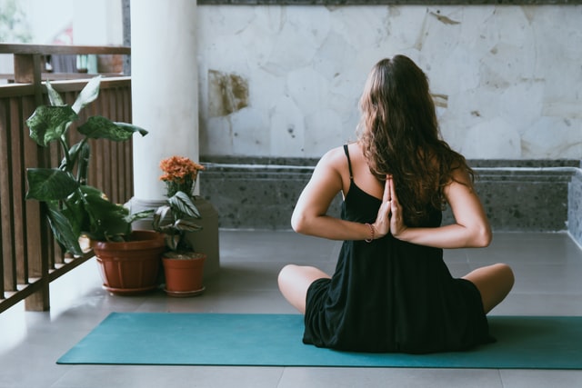 A woman sitting practicing reverse prayer pose
