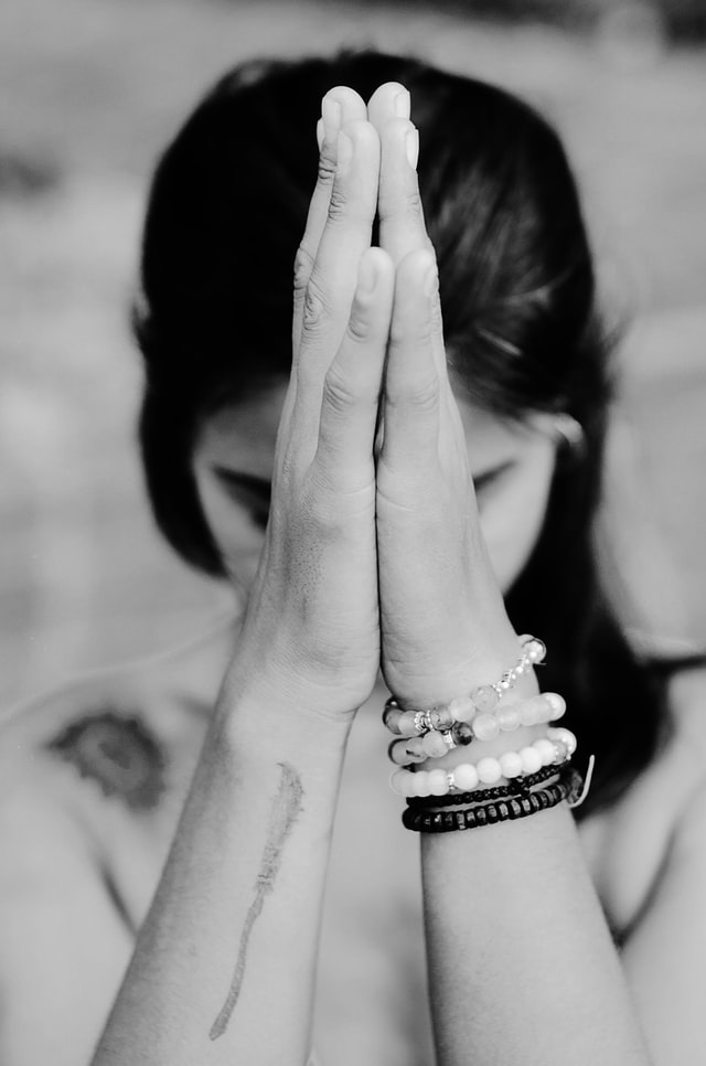 A black and white photograph of a woman praying
